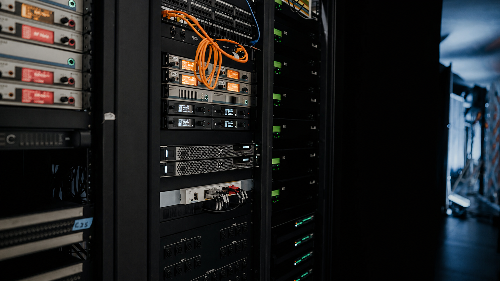 Installed server and network equipment with orange cabling inside a rack.